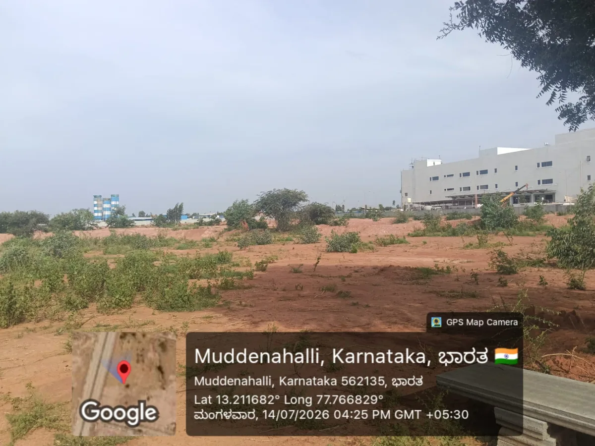 Prestige Parklane site photo taken July 2026 showing the levelled 11.90 acre residential plot at KIADB Aerospace Park Phase 2, Devanahalli, with the industrial estate behind